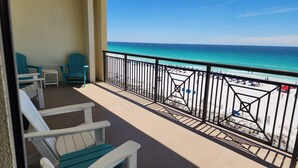Ein Balkon mit Stühlen und Blick auf den Strand, ausgestattet mit einer Geländer.