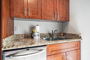 A kitchen with granite countertops, stainless steel appliances, and wooden cabinets.