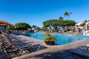 A pool area with lounge chairs, a potted plant, and a clear blue sky. - Maui Hill 70 - Spacious 3BR/3BA for 8, 2 King Suites, 3 Lanais, Pool, Near Beach (Kihei)