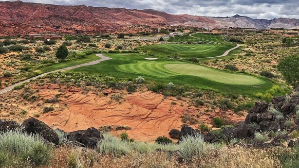 A golf course with a desert landscape, including red rock formations and sparse vegetation. - The Desert Hideaway, Small place, big adventures (St George)