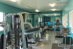 Ein Fitnessstudio mit verschiedenen Trainingsgeräten, darunter Laufbänder und Kraftgeräte.