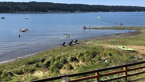Une vue sur le lac, avec des bateaux, des kayaks et des personnes sur la rive.