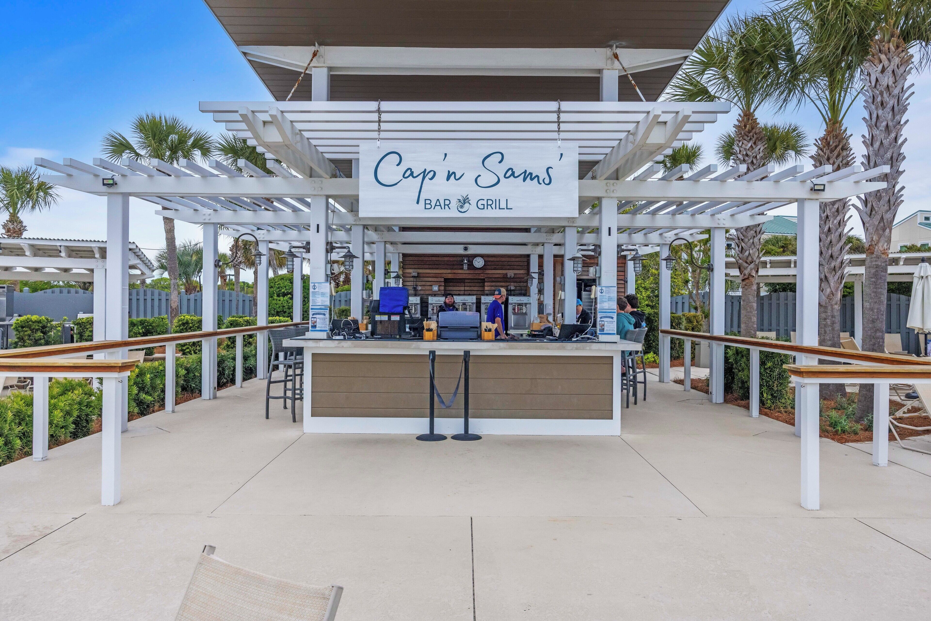A covered outdoor seating area with a sign for 'Cap'n Sams' Bar & Grill.'