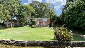 A two-story building with a stone wall and a small garden area.