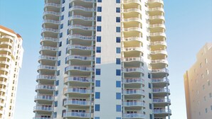 Un immeuble de grande hauteur doté de nombreux balcons, probablement un hôtel ou un ensemble d’appartements.
