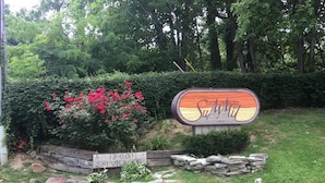 A sign for a ski resort with a wooden fence and a stone wall, surrounded by greenery and a clear sky. - Everyone Welcome! Private WiFi, Heated Pool, Gas Grills, Catch the View! (Gatlinburg)