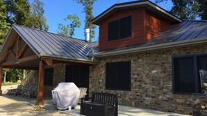 A stone house with a covered patio, a barbecue grill, and a covered seating area. - Make your reservation fast as inquiries are coming in daily.  (Redford)