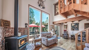 Una sala de estar acogedora con chimenea, un sofá cómodo y una escalera que sube a un nivel superior.