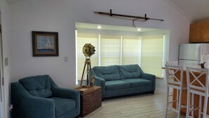 A living room with a sofa, a chair, a tripod, and a table. - Bird watching paradise! (Seadrift)