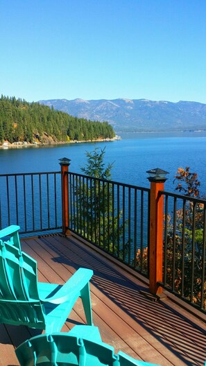 A deck with chairs overlooking a lake and mountains. - Waterfront House On Camp Bay, near Sandpoint with Dock and swimming area. (Sagle)