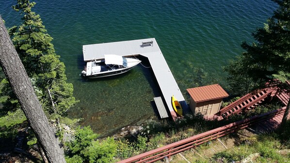 A dock with a boat, clear water, and a small building. - Waterfront House On Camp Bay, near Sandpoint with Dock and swimming area. (Sagle)
