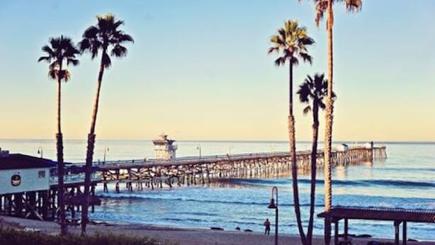 A beach with palm trees, a pier extending into the water, and a lifeguard tower. -  🏄GREAT LOCATION: FAMILY & PET FRIENDLY BEACH COTTAGE🌊 (San Clemente)