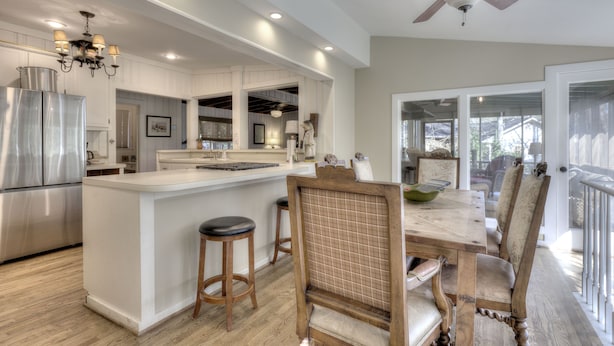 A modern kitchen with a central island, wooden chairs, and a ceiling fan. - Hattiway on Lake Allatoona Includes Private Covered Dock (Lake Allatoona)