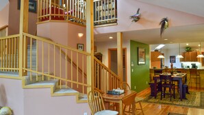 A multi-level home with a staircase, dining area, kitchen, and a balcony with a bird sculpture. - Beautiful, pet friendly and at the foot of Saxon Mountain in Georgetown Colorado (Georgetown)