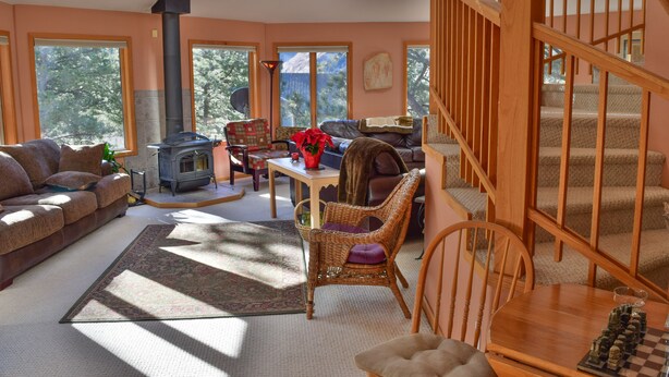 A cozy living room with a fireplace, a dining area, and a staircase. - Beautiful, pet friendly and at the foot of Saxon Mountain in Georgetown Colorado (Georgetown)