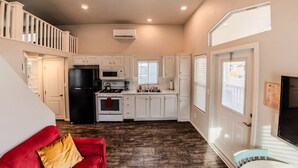 A compact kitchen with white cabinets, a black refrigerator, and a microwave. - Pet-Friendly Moab Tiny Home Near Arches | Sleeps 6 | Private Porch | Desert View (Moab)
