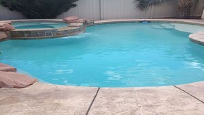 A swimming pool with a curved design, surrounded by a stone deck. - Vacation paradise (Las Vegas)