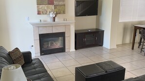 A living room with a fireplace, a flat-screen TV, a sofa, and a coffee table. - Vacation paradise (Las Vegas)