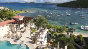 A resort with a pool, lounge chairs, and a view of the sea with boats. - Grande Bay Condo Beautiful Morning- 3 Bedroom - Wraparound Balcony- Views!! (St John)