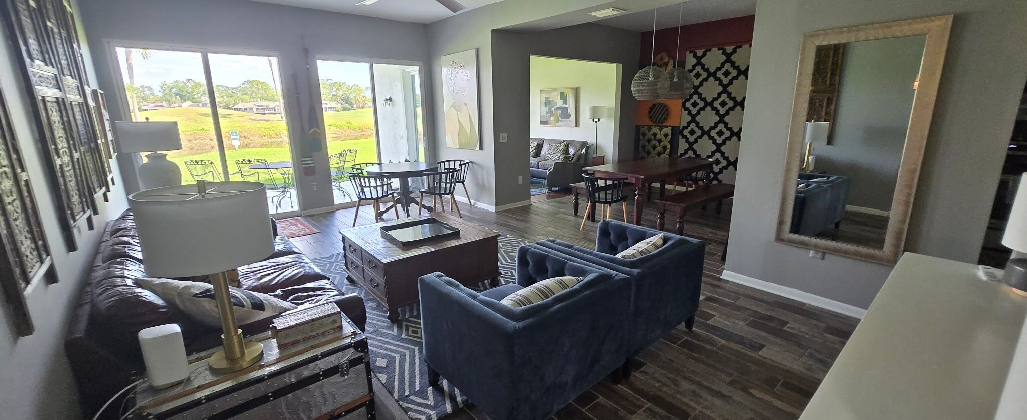 Un salón amplio con sofá, una mesa de comedor y sillas. Una ventana grande ofrece vistas al exterior.