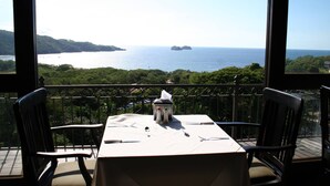 Tavolo imbandito per due con vista sul mare e sul verde.