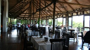 Una sala da pranzo interna con travi in legno e tavoli apparecchiati per gli ospiti.