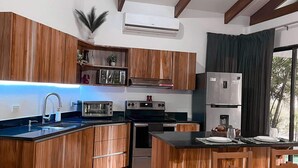 Una cucina moderna con mobili in legno, forno a incasso e una grande isola con posti a sedere.