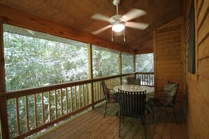 Enjoy a peaceful retreat with a balcony offering a round table and four chairs, overlooking a dense forest.
