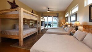 Een hotelkamer met stapelbedden, een groot raam en een plafondventilator.