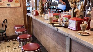 Eine Bar mit Hockern, einer Speisekarte und verschiedenen Barutensilien.