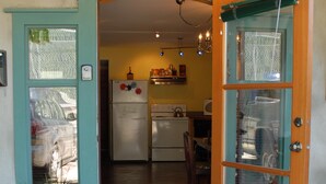 A kitchen with a refrigerator, stove, and hanging lights. - Downtown 1BR suite, ground floor, level entry. (Nelson)