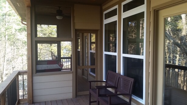 A covered porch with a wooden bench, large windows, and a ceiling fan. - “A Shore Thing “ A Gorgeous Lakefront Home Steps Away From Beaver Lake (Garfield)