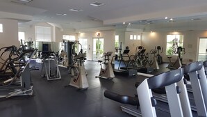 A gym with various exercise equipment, large windows, and a clean, modern design. - Penthouse - Resort living (Irvine)