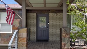 A house with a dark blue front door, a stone facade, and a number '1671' above the door.