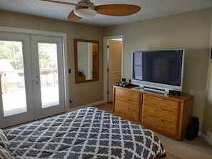 A bedroom with a bed, dresser, TV, and a ceiling fan. - 1 of the Safest neighborhoods in America. Unique one of a kind with Hot Tub. (Sandy)