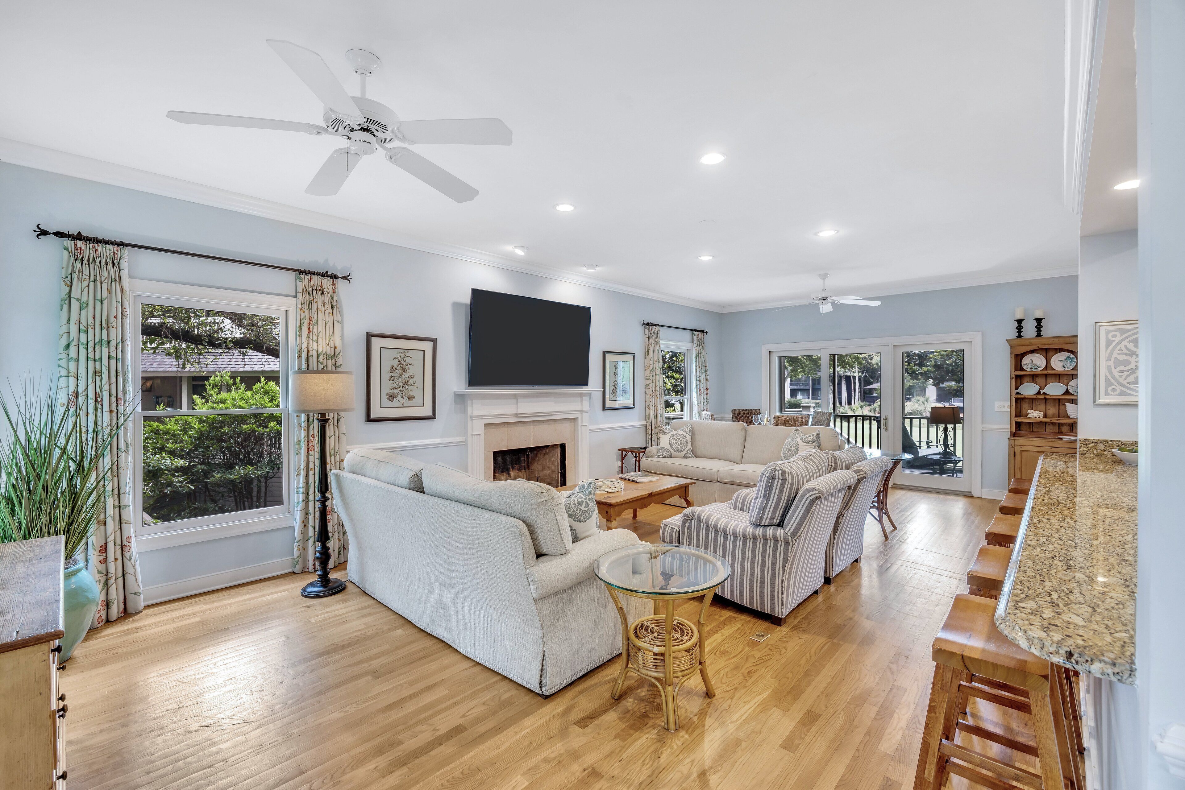 A spacious living room with a fireplace, sofas, a coffee table, and a TV.