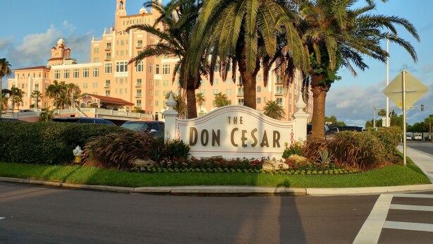 A sign for The Don Cesar hotel with a large building in the background.