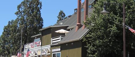 Un edificio con un letrero que anuncia un café de sopas y similares, una gran chimenea y banderas estadounidenses.