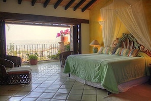 Enjoy a sea view from the balcony, featuring a comfortable bed and seating area.
