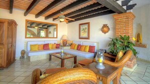 A cozy living area with a sofa, wooden furniture, and a brick fireplace.