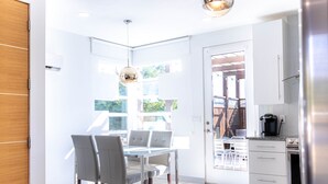 A modern kitchen with white cabinets, a stainless steel refrigerator, and a coffee maker. - Fox Den at Fox Hollow (Aldrich)