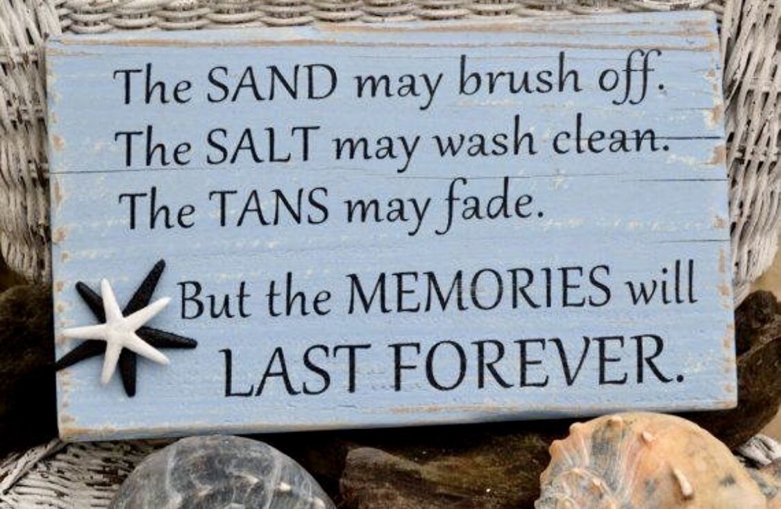 A wooden sign with a message about memories lasting forever, surrounded by seashells and a starfish decoration.