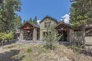 A two-story house with a stone facade, a front porch, and a small front yard.