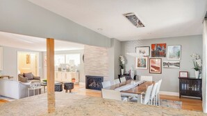 A spacious living area with a fireplace, dining table, and modern decor.