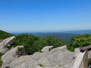 A mountainous landscape with rocky outcrops and dense green foliage.