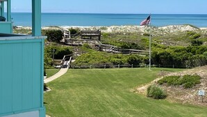 Küstliche Aussicht mit einer grasbewachsen Fläche, Holzbauten und einer amerikanischen Flagge.