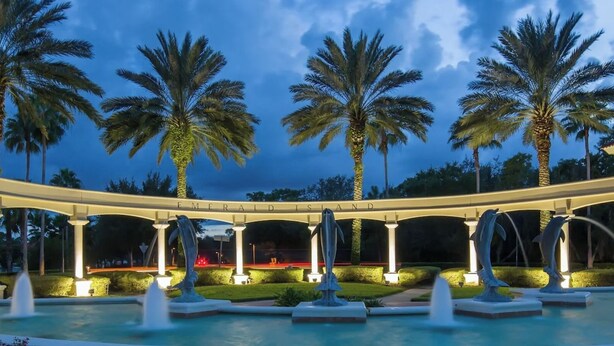 A bridge with palm trees and a fountain in the foreground. - Florida Winter Escape 🌴 6BR Private Pool Snowbird + Family Visits (Kissimmee)