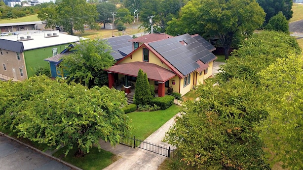 A two-story house with a red roof and solar panels. - Your Next 5 Star Get Away! (Little Rock)
