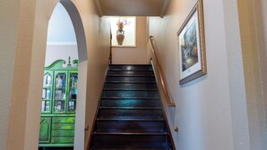 A wooden staircase with a handrail, leading to a landing with a light fixture and a framed picture on the wall. - Your Next 5 Star Get Away! (Little Rock)