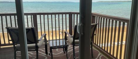 A balcony with a view of the beach and ocean.